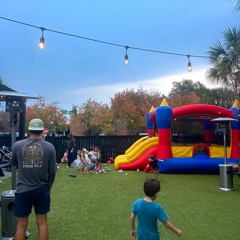 Family night on the turf at OTH, with a bounce house, string lights and kids playing