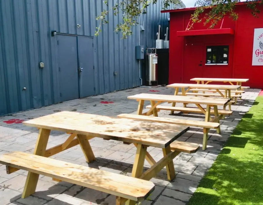 The outdoor patio with picnic tables and turf