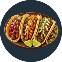 Four mix-and-match tacos on a wooden platter with pickled onion, salsa verde, cotija and lime wedges